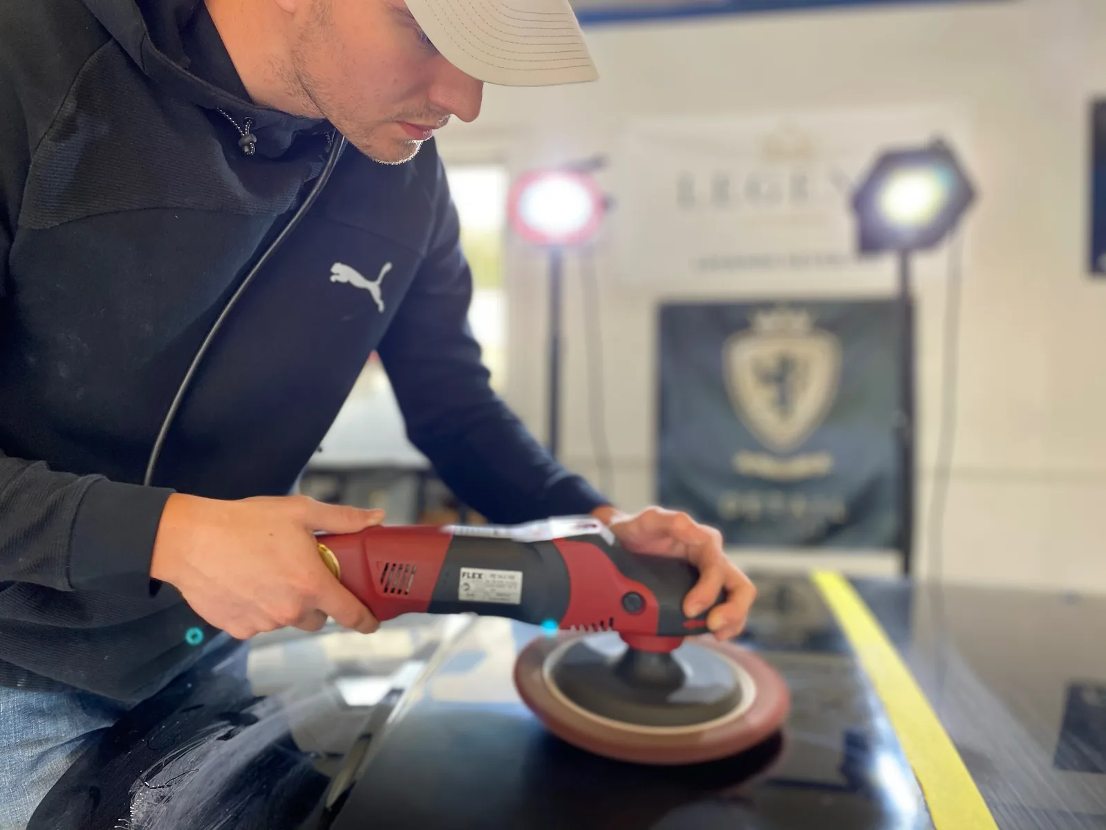 James polishing a black hood with a rotary machine