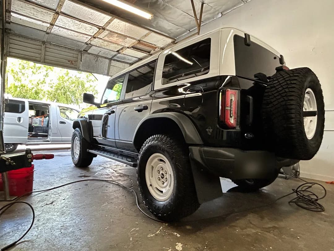 Black Ford Bronco with a white roof freshly detailed in the shop
