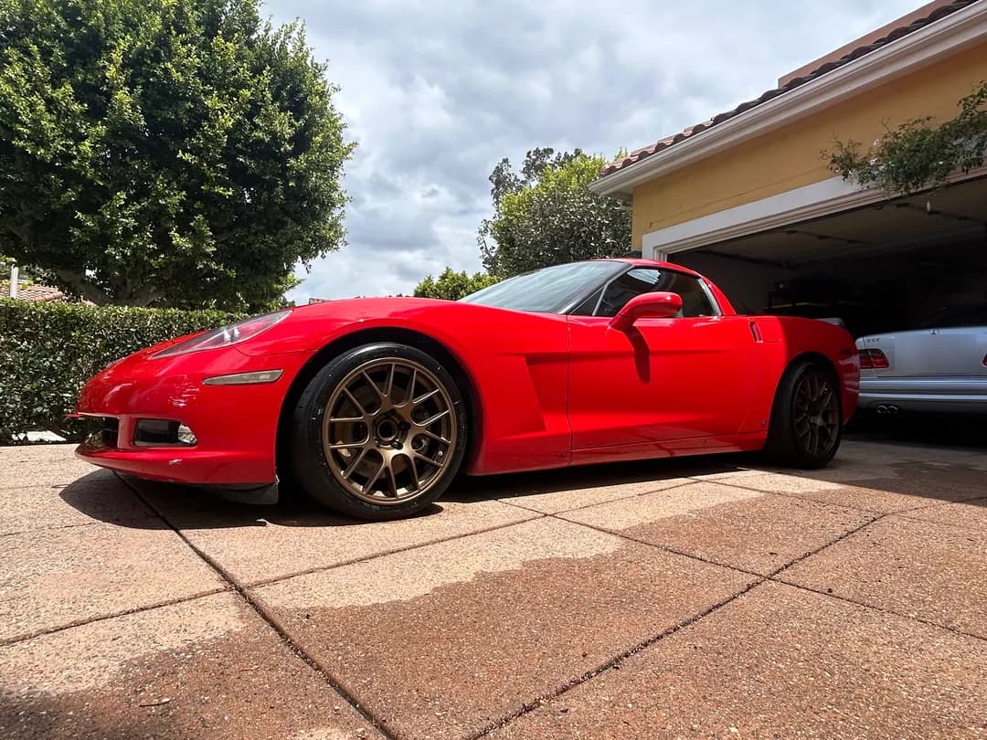 Red Corvette freshly detailed in a client's driveway