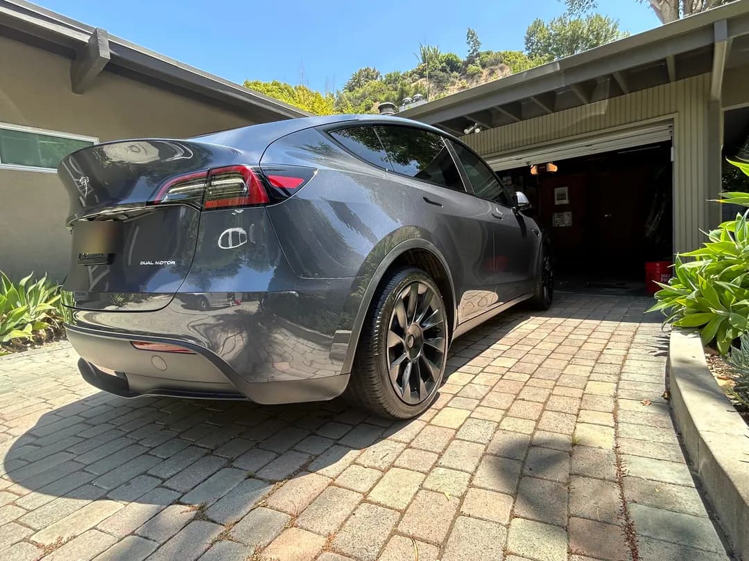 Grey Tesla Model Y freshly detailed in a client's driveway